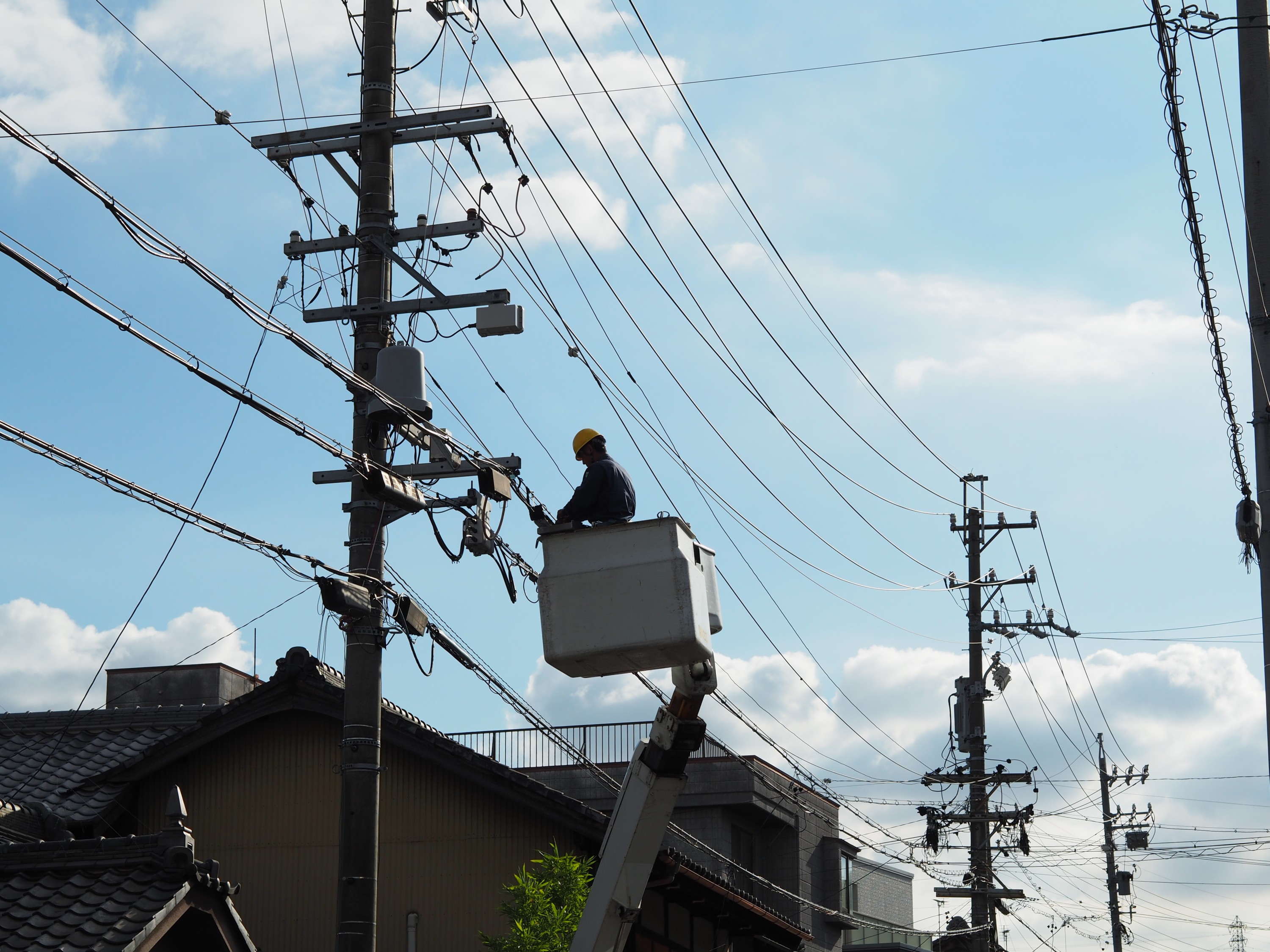 高所作業車のゴンドラに乗って電線の補修を行